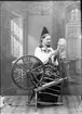 Lotten Lindgren klädd i folkdräkt spinner, Dalarna 1893