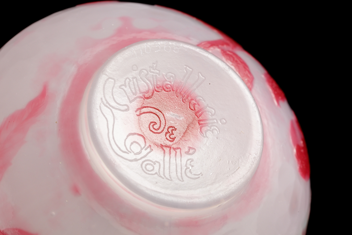 Skål med opaliserande vitt glas och mörkrosa överfång. Dekor av svagt stiliserad kvist med äppelblom. Gröna fläckar på insidan bakom bladen.