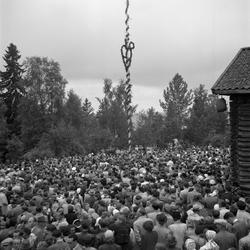 Motiv: (ingen anteckning) ;
En folksamling står kring en midsommarstång, en folksamling vid ett hus, en kyrkbåt ros av kvinnor och män i folkdräkt, en folksamling står vid en brygga med en kyrkbåt.