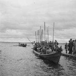 Motiv: (ingen anteckning) ;
En folksamling står vid en brygg