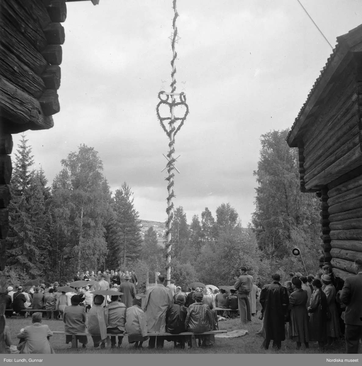 Motiv: (ingen anteckning) ;
Två män i folkdräkt håller fioler, en man i en talarstol talar till en folksamling, ett barn sitter på trapan till en talarstol, en folksamling vid en midsommarstång, porträtt av två varav ett i folkdräkt, kvinnor och män i folkdräkt dansar vid en midsommarstång.