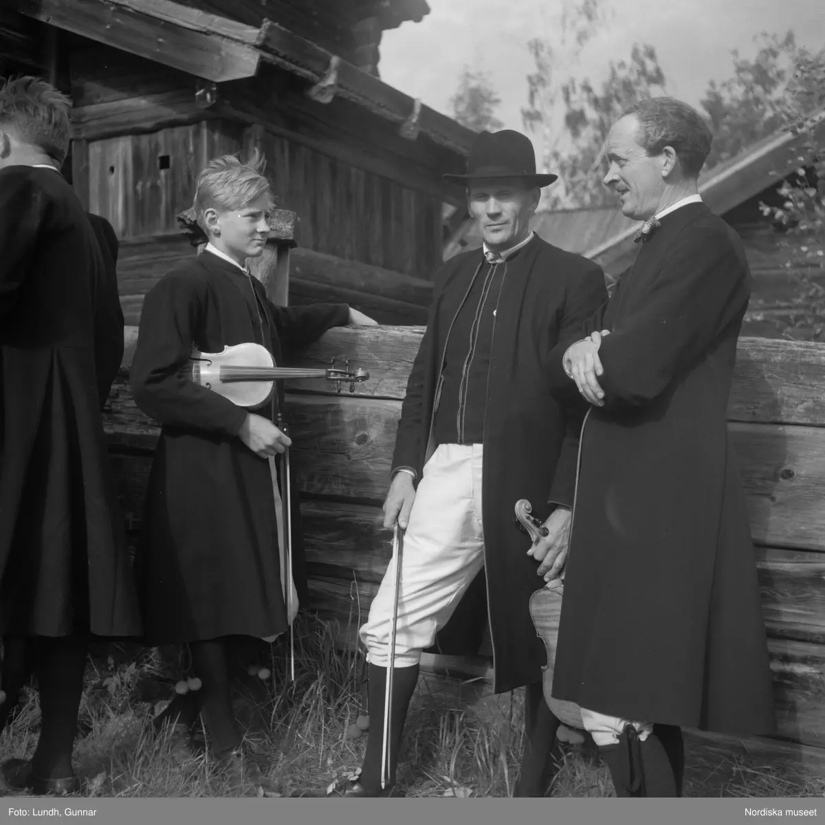 Motiv: (ingen anteckning) ;
Porträtt av en man - ett barn och en kvinna i folkdräkt, två kvinnor i studentmössor, män klädda i folkdräkt spelar fiol.