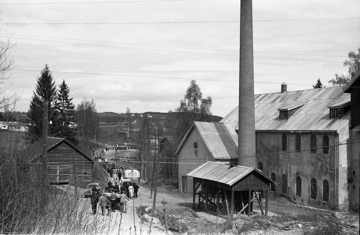 Avfotografert bilde av et 17-mai tog som nettopp har passert Kjølset Brenneri på veg mot Skreia sentrum. Brenneriet til høyre i bildet.