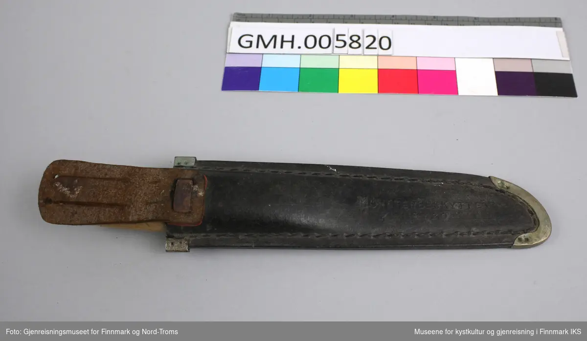 Kniven består av et håndtak av lyst tre som er transparent lakket og en klinge med avbrukket spisse. I klingen er det preget inn en referanse til produsenten "B. Knudsen Ilen Trondhjem" og anledningen kniven fikk ny eier "Krigsweihnachten 1941 Husoen". Det refereres altså til jul under krigen og mest sannsynlig til Husøya, en øy i øygruppa Tarva i Sør-Trøndelag, der det befant seg et tysk kystfort. 
Slira er laget i skinn og har et mønster innpreget på forsida som viser navnet "Norge" øverst, en fugl og florale ornamenter under. Kantene er forsterket med metall. På baksida av slira er det innpreget "Mønsterbeskyttet 14720" og i tillegg festet en holder å henge den i et belte.  