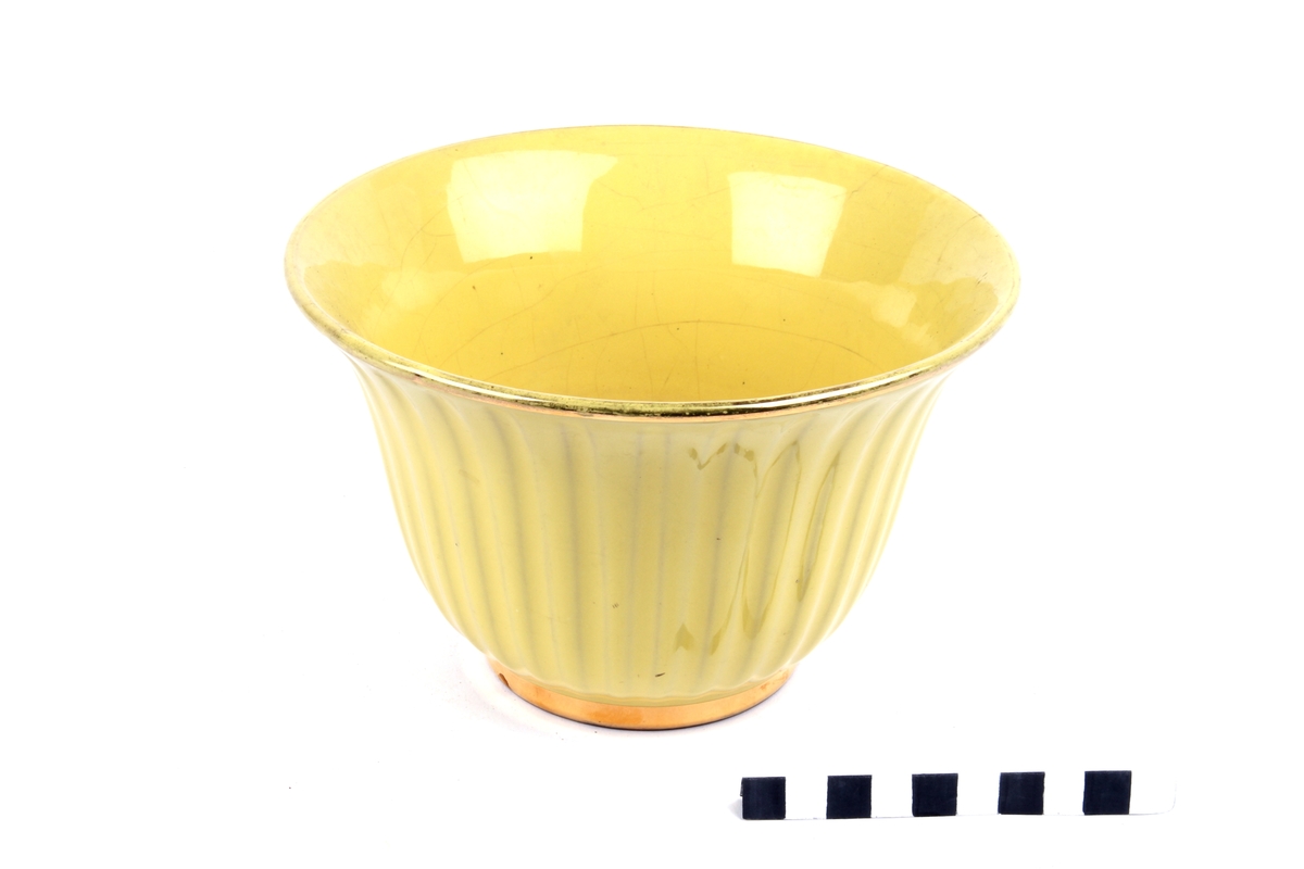 Blomsterpotte med rillet dekor og med gul, blank glasur og gullfarget kant.