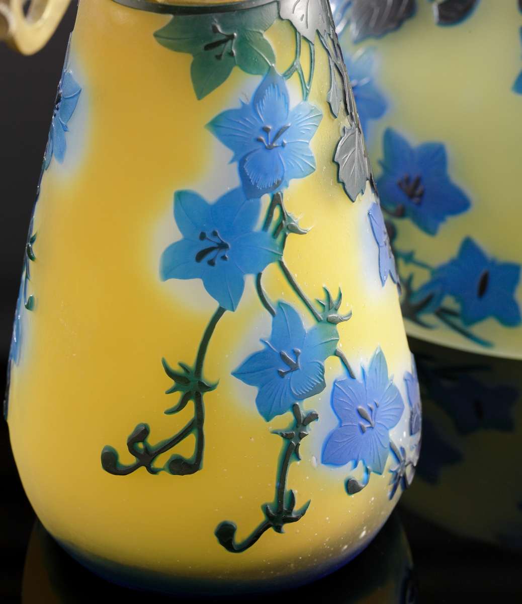 Opak, gul lampa med etsat överfång i olika blå nyanser.
Metallfattning för glödlampa. Tvinnad textilsladd.