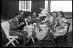 Familjen Axel Jonsson, Torvelunne, Götlunda socken firar Mors dag med kaffebjudning i trädgården.