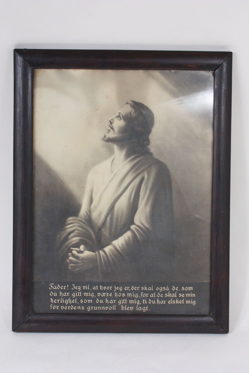 Motivet er Jesus i bøn, ein variant av den svenske kunstnaren Bertha Valerius sitt "Jesus i bønn" frå slutten av 1800-talet. Trykket er i svart/kvitt. Under motivet er trykt bønetekst i gotiske boktavar, sjå undet Innskrift. Konveks treråme. 
På baksida skrive med blyant: kr. 1,25- S. R.
Sjå også SUM.08175, SUM. 08176, SUM.06000.