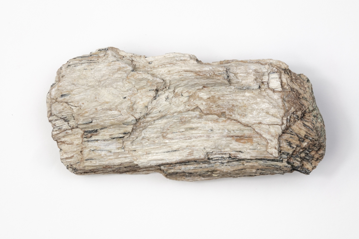 Ett mineral är en amfibol. Mineralet är långfibrigt och känt för att ha hög isolerande förmåga både vad gäller ljud och värme. De hälsoskadliga effekterna är dock högst påtagliga. Exemplaret kommer från Tyrolen i Österrike och ingår i Adolf Andersohns samling.