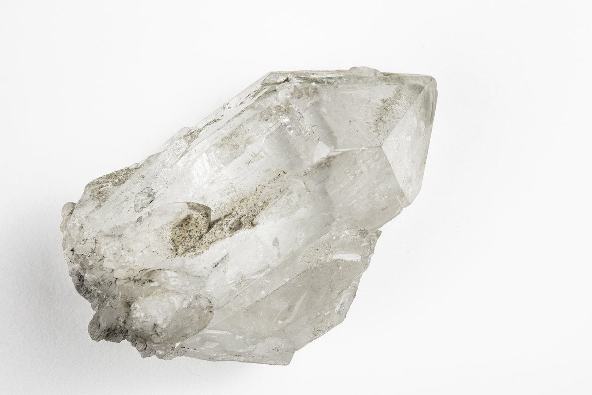 Ett mineral som är en kvarts och består av kiseldioxid. Mineralet har kristallform, är färglös och klar och används ofta i smycken. Detta exemplar har okänt ursprung men ingår i Adolf Andersohns samling.