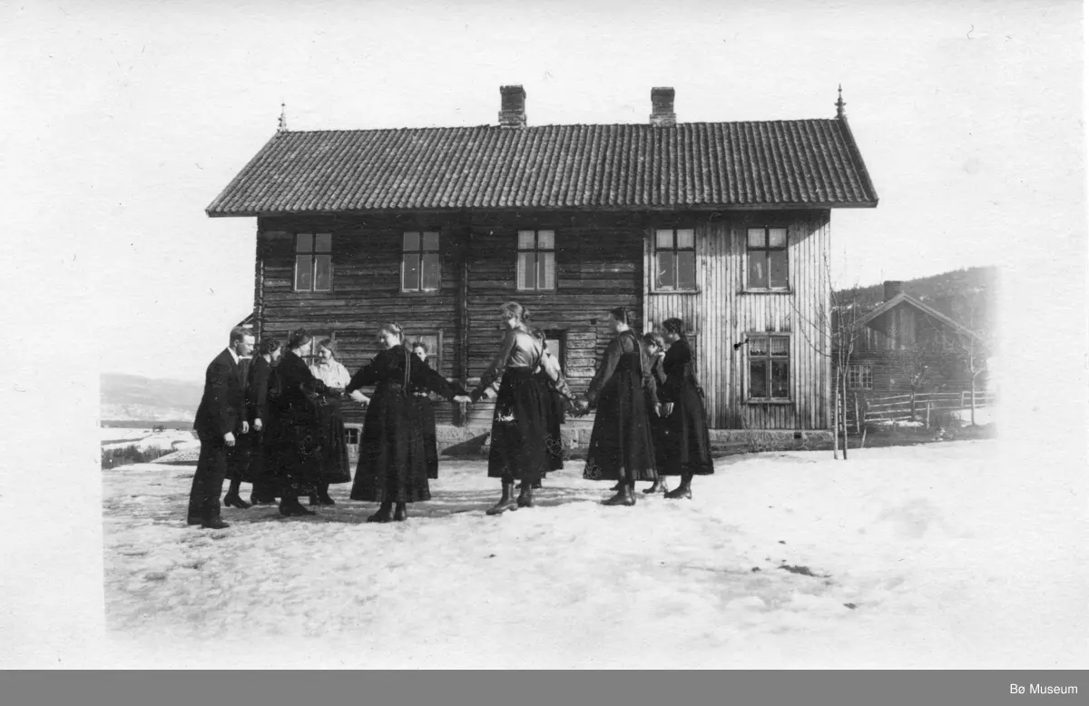 Frå tunet på Torstveit, nordre.
Ungdomar dansar i ring.