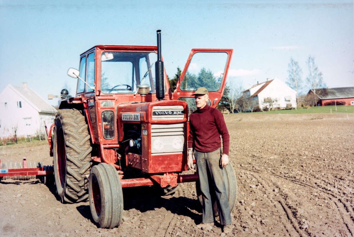 Odd Hjermstad (1925-1997) foran en Volvo BM 650 traktor på Hjermstad Gård, 86/1.  Såstadvegen 160. Tromling, våronn.