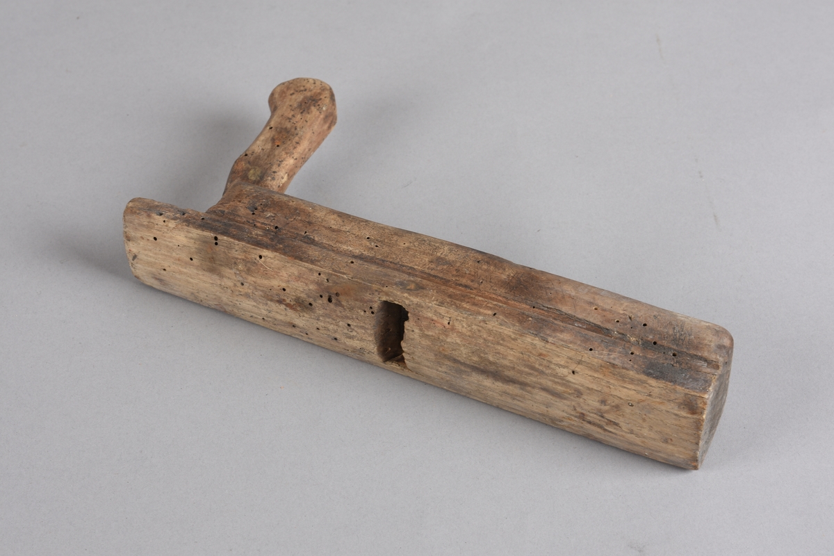 Høvel med rektangulær stokk, horn (handtak) med avrunda ende. Stokken er svakt runda på tvers på undersida. Har spor for høveljern og kile. Skoren dekor på toppen framom sponutkastet.