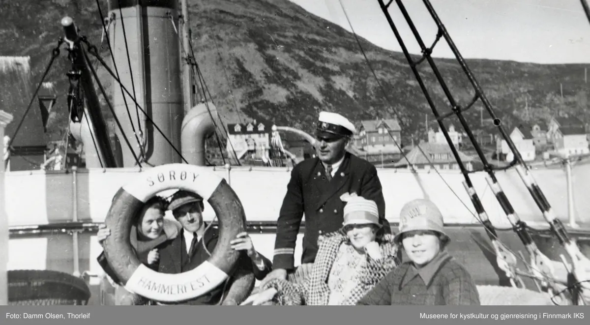 Honningsvåg havn. Passajerer og en offiser på dekk ombord i D/S "Sørøy". I bakgrunnen deler av bebyggelsen. 1930-årene.