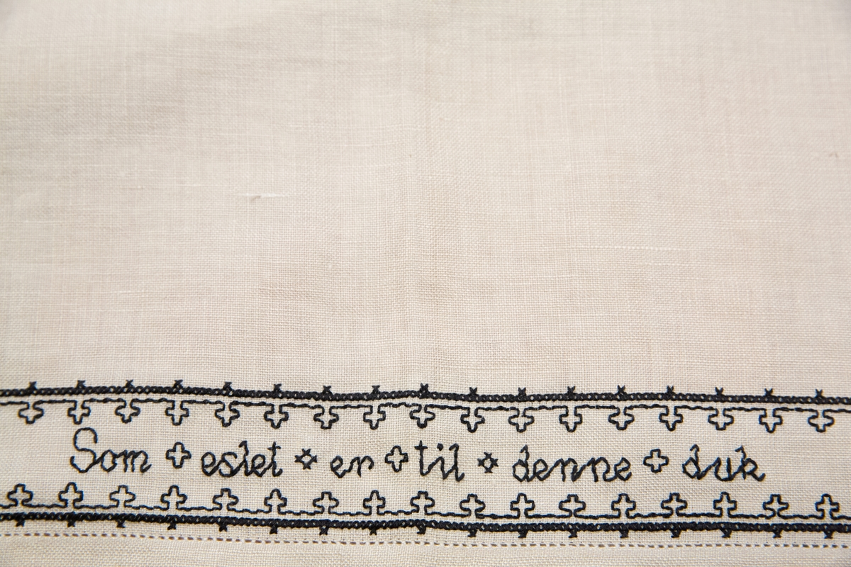 Brodert mønster og bokstaver. Tekst. 

Om symbolikken: Borden med motsatte kors skal symbolisere falne på begge sider under krigen. Her fins referanser til Maginotlinjen og slagene ved Pantelaria, Lampedusa og Midway. Langs kanten rundt er det bodert inn verslinjer.