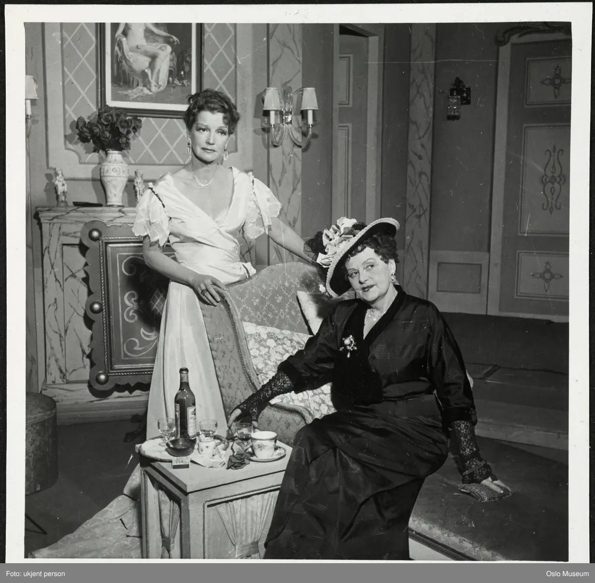 dobbeltportrett, kvinner, skuespillere, rollebilde, Madame Oeloux i "Cherié" på Trøndelag Teater, stående og sittende helfigur, kostymer