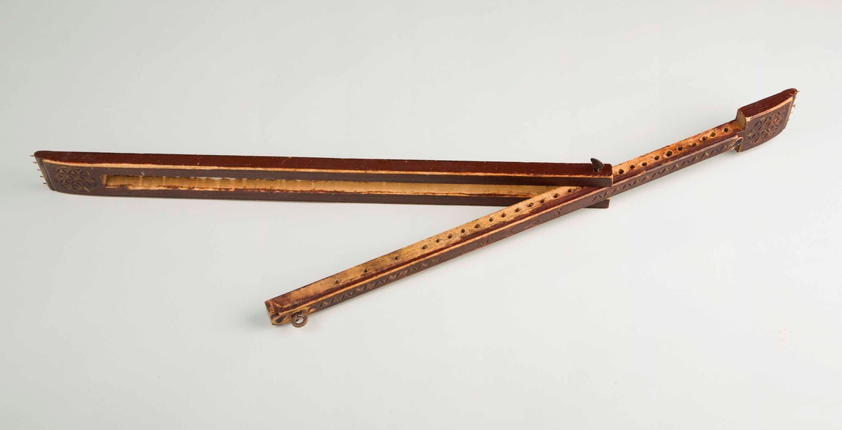 En rødbrun avlang spenne i tre som kan trekkes ut