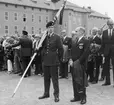 Söderm. Regementes Officerares Kamratförening (Lilla kf) tidigt 1970-tal

Okänd ceremoni på kaserngården, kan vara allmän besöksdag vid regementet.
Bild 1
T.v. med ryggen häråt överste Ragnar Tauvon, brigad- och utbildningschef.
Fanförare löjtnant Hans Norlén och överste Gunnar Henricson.
Bild 2
Utöver de på bild 1 ser vi regementschefen överste 1. Stig Colliander längst t.h.