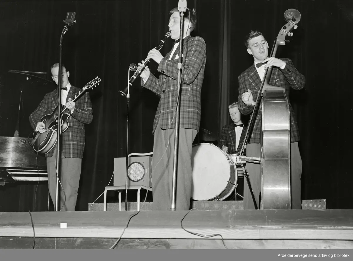 Grewe Combo fra Horten spiller på amatørkonkurranse for norske jazzband - Norgesmesterskap i jazz. Arrangert 24. november 1957 i Oslo. Fra venstre; Knut Greger Eriksen på gitar, Rolv Wesenlund på klarinett, Knut Lind Frodesen på trommer og Oddvar Kjærran på bass.