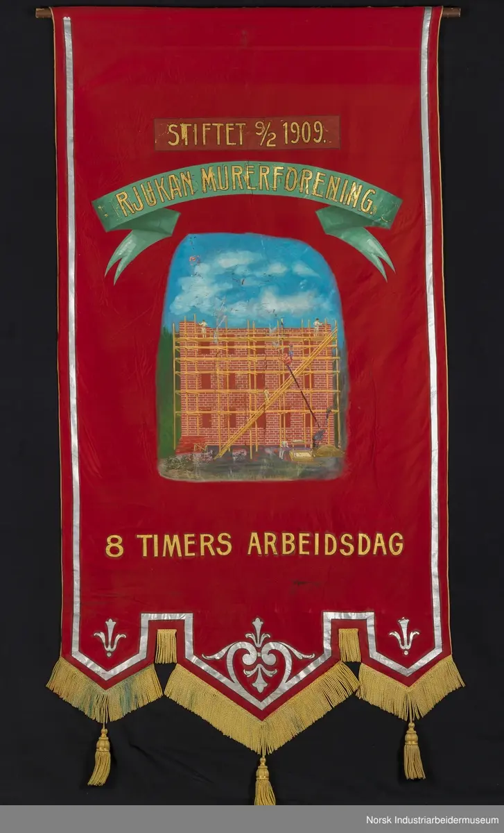 Side 1: Bygg som mures opp, stillas, arbeidere, blå himmel bak. Sølvbånd langs kantene.
Side 2. Sølvornament og sølvbånd langs kantene.