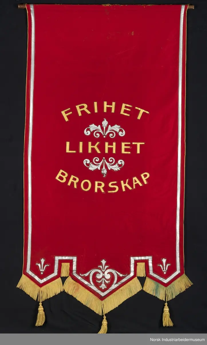 Side 1: Bygg som mures opp, stillas, arbeidere, blå himmel bak. Sølvbånd langs kantene.
Side 2. Sølvornament og sølvbånd langs kantene.