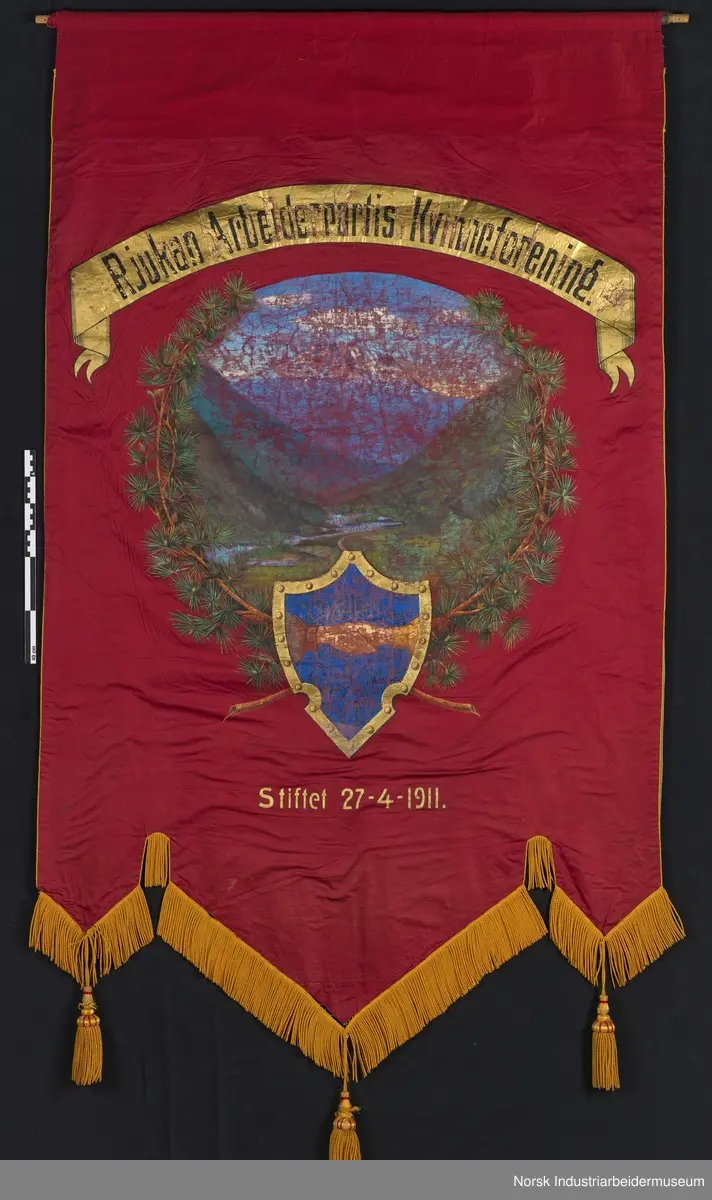 Side 1: Omkranset av furukrans, bilde av Gaustatoppen? og Vestfjorddalen (fra Miland?)
Nederst: Håndtrykk, blå bakgrunn
Side 2. Stjerne i gull oppe, bjørkekrans bundet med norsk flaggbånd, håndtrykk. Øverst malt kappe (illusjon) rød og gull, med folder og frynser