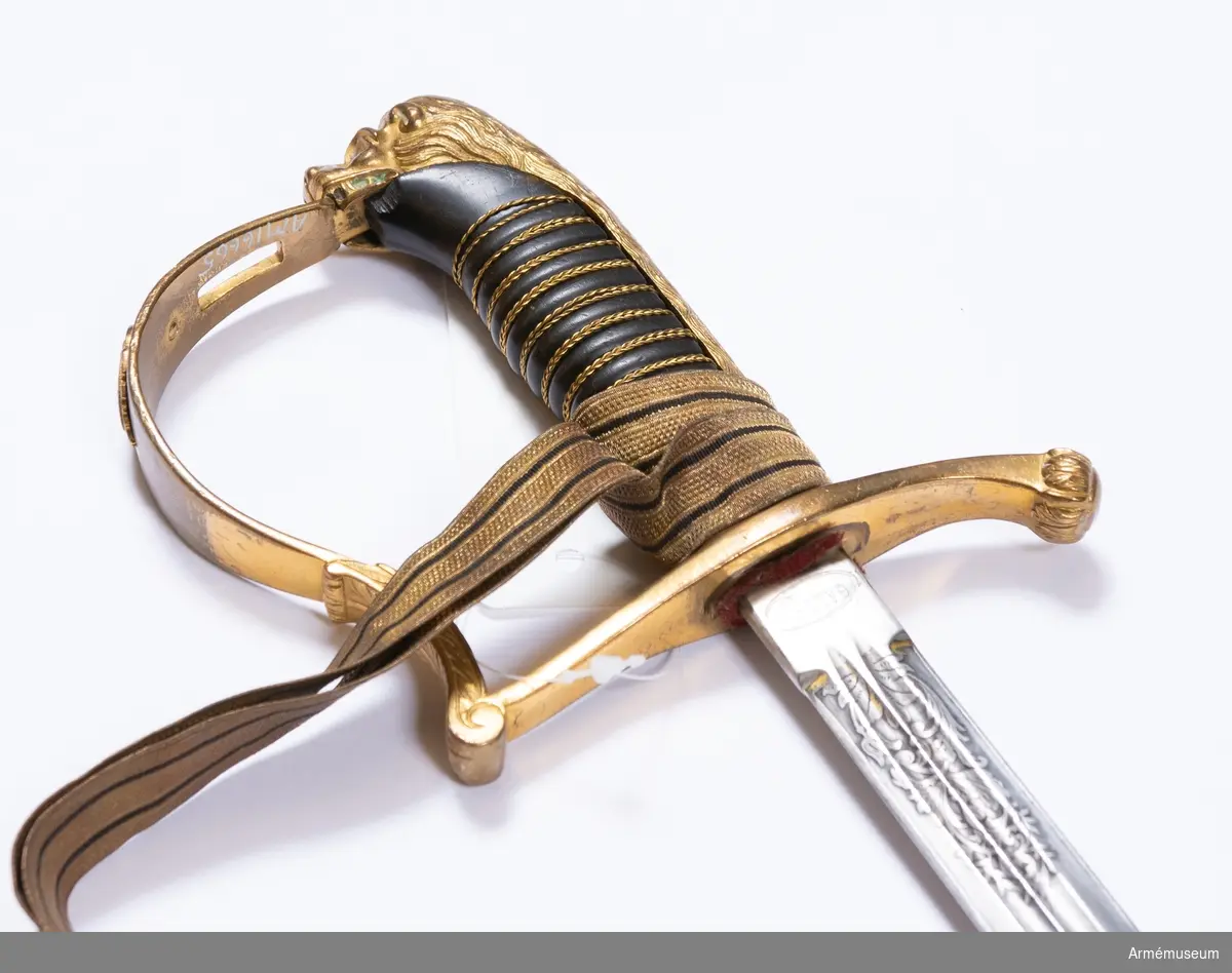 Sabel m/1899 för officerare och fanjunkare vid infanteriet och fortifikationen.
Sabeln är fullkomligt lik AM 39947. Upptill på klingans yttersida står "GALON. IMP." inom en oval  ram och på samma ställe på innersidan en kronstämpel med  bokstäverna J.V. och G. L.