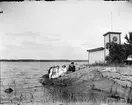 Kvinnor och man sitter på klipporna vid Kallbadhuset, Östhammar, Uppland