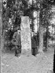 Algot Lindqvist och Sara Edhlund vid en runsten i Harg, Uppland