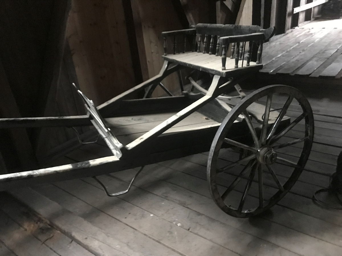 To-hjuls vogn for én hest til persontransport. Stolkjerre, firkantet fating med lave, skrå sider. Hovedsetet har lavt ryggstø med dreiede spiler i rygg. Setet har fjærende trearmer og en tverrgående elliptisk helfjær. Stolkjerra er har sekundær overflatemaling, sekundær påskrift på rygglenet og påmalt blomst på fatingens bakside. Fløy av jernblikk. Passasjersete bak. Akseltapp: Grease med løntestikke.
Informant om bruk, benevning, datering: Bjørn K. Høie, 2019.