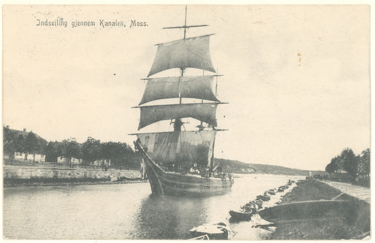 Serie på flere bilder. Fotograf har stått like ut i kanalparken på Jeløysiden.
Detaljer: Sveivebroen er sveiet inn, barken "Alfred Gibbs" seiler gjennom, Tollboden, fiskebasaren, folk.
Historikk: Slike store seilskip ble gjerne trukket gjennom kanalen om det ikke var nok vind.