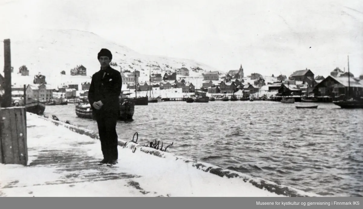 Honningsvåg. Toller Thorleif Damm Olsen på dampskipskaia. I bakgrunnen kirka og deler av bebyggelsen langs havna. 1930-årene.