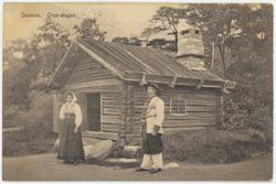 Vykort med motiv från Skansen. "Orsa-stugan". Man och kvinna