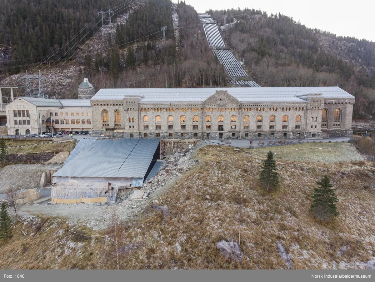 Bygningen var opprinnelig Vemork Hydrogenfabrikk som var plassert fem meter foran Vemork gamle kraftstasjon. Bygget var i betong i 8 etasjer. Driften i bygget stoppet i 1971 og ble i 1977 revet ved sprengning. Telemark Fylkeskommune initierte en utgravning på tomten for om mulig å finne rester etter den gamle kjelleren i 2017. 18.09.2017 startet arbeidet og kjelleren ble i november funnet inntakt.