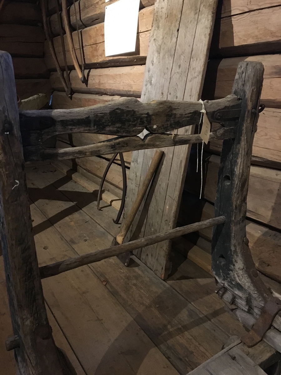 Høyslede (transport av vinterfôr) med høy bakkarm og lav framkarm. Dragfeste for slededrag. Hengsler til forkarm. Treplugger på begge sider av bukkene ned i meier. Krok til grinder på bakkarm. Tverrbrett med gjennomskåret dekor. Transportredskap til hest hovedsakelig brukt av menn.

Tilstand: slitt