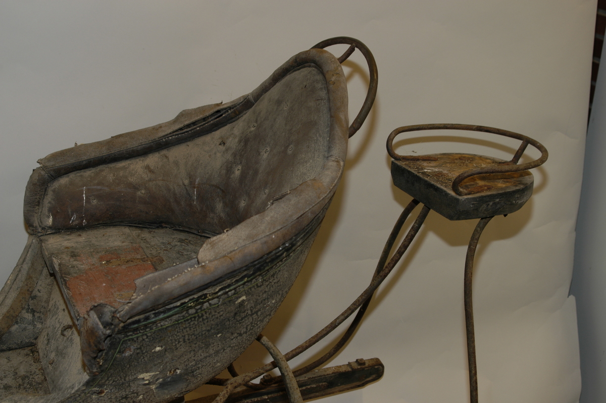 Spisslede av empiremodell fra før 1890. Forholdsvis stor, høy nettingskjerm foran. Romslig hovedsete trukket med skinn. Messingbelagt tomløper. Spesiell form på omramming på skvettskjerm. Smidde beslag, krussedull stiver av skjermen. Feste for skjeker (skjeker mangler). Sleden er reparert på museet. Personkjøretøy for hest til vinterføre brukt av kvinner og menn.