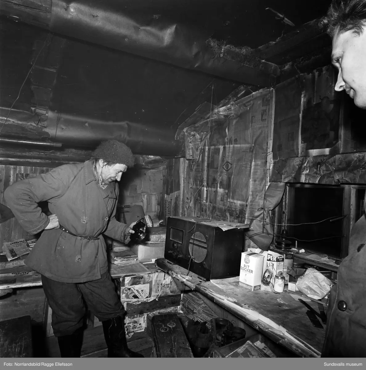 Tidigare skidlöparstjärnan Lars-Teodor Jonsson i sin bostad, en enslig skogskoja i Lill-Allvattnet, Strömsund, där han levde till nära 90 års ålder. Stugan har senare flyttats och finns bevarad på hembygdsgården i Strömsund. Reportagebilder för Expressen.