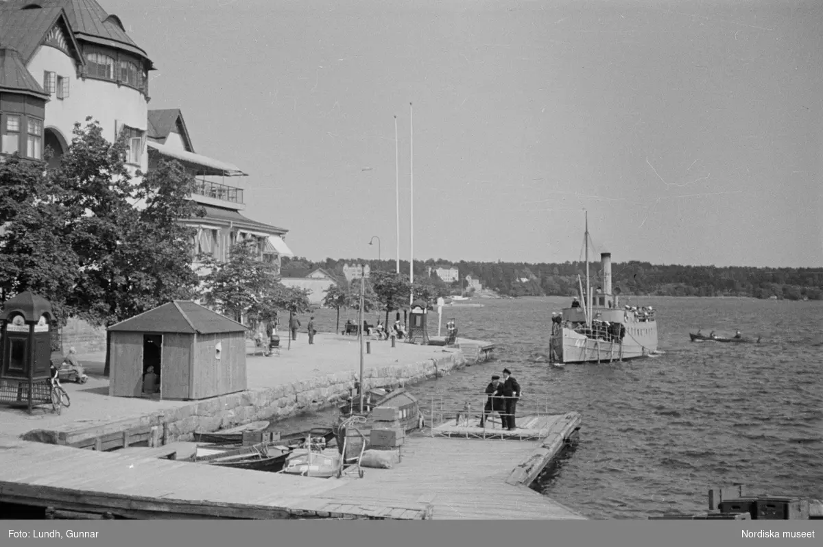 Motiv: Stockholm - Vaxholm;
Människor på en brygga med skylt "Edlunda", en segelbåt, människor på en brygga med skylt "Höganäs".

Motiv: Vaxholm;
Människor står på en brygga och en båt lägger till, en segelbåt, två män lyfter backar med flaskor på en brygga, folksamling vid möbler utställda på en grusplan (troligen en auktion).