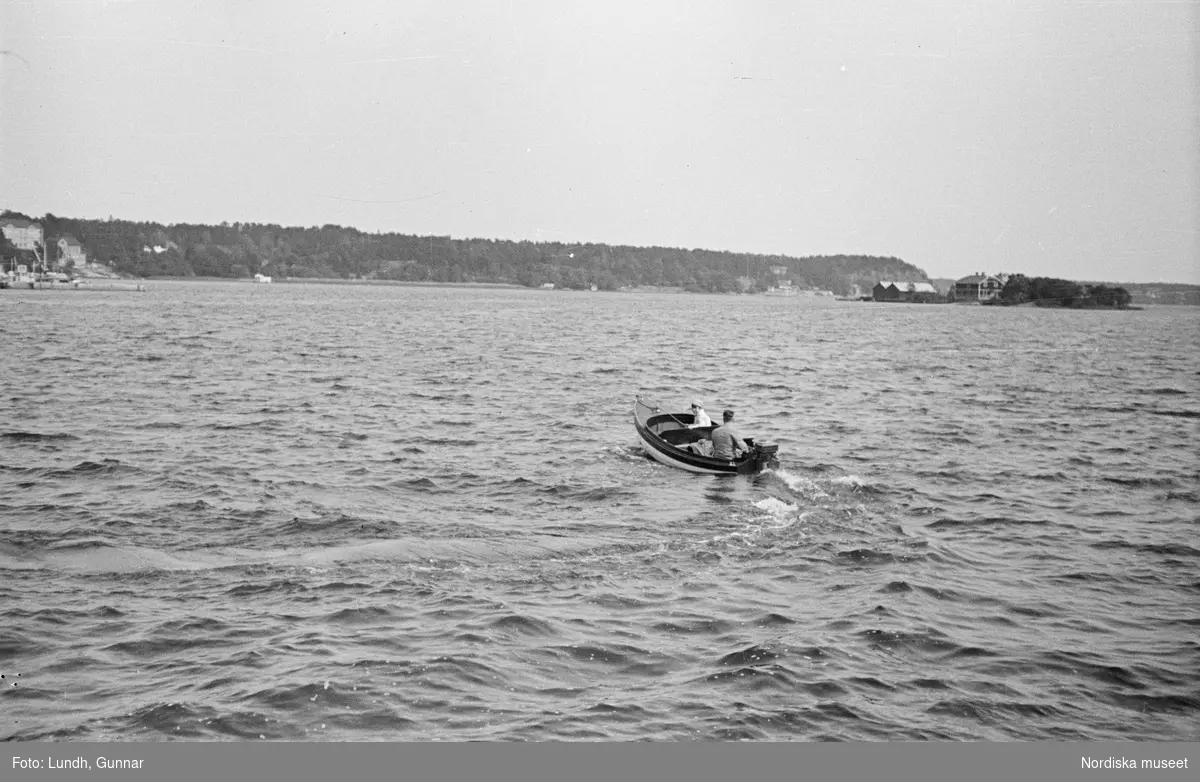 Motiv: Stockholm - Vaxholm;
Människor på en brygga med skylt "Edlunda", en segelbåt, människor på en brygga med skylt "Höganäs".

Motiv: Vaxholm;
Människor står på en brygga och en båt lägger till, en segelbåt, två män lyfter backar med flaskor på en brygga, folksamling vid möbler utställda på en grusplan (troligen en auktion).