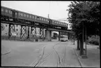 Persontåg passerar på Västkustbane viadukten över spårvägen på Drottninggatan vid Halalid där Helsingborgs Stads Spårvägar, HSS spårvagn trafikerar.