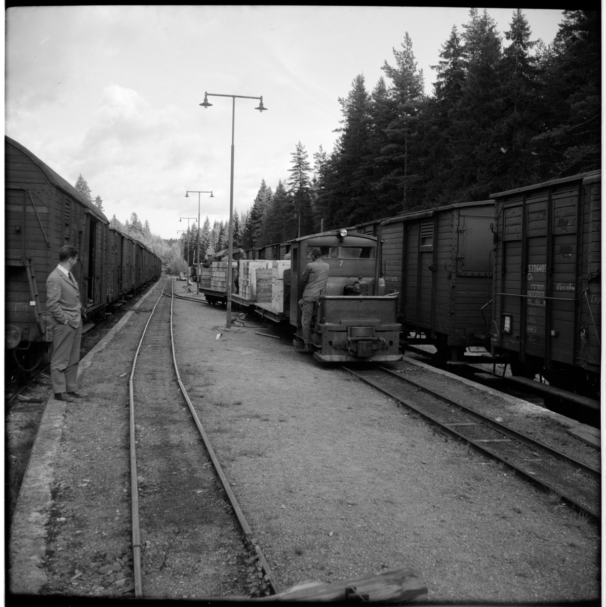 Vid Käppsta trafikplats under Gyttorps järnvägsstation. 
Lokomotor 7 för smalspår kopplad med tre lastade godsvagnar. Statens Järnvägar, SJ Go26403 till vänster i bild.