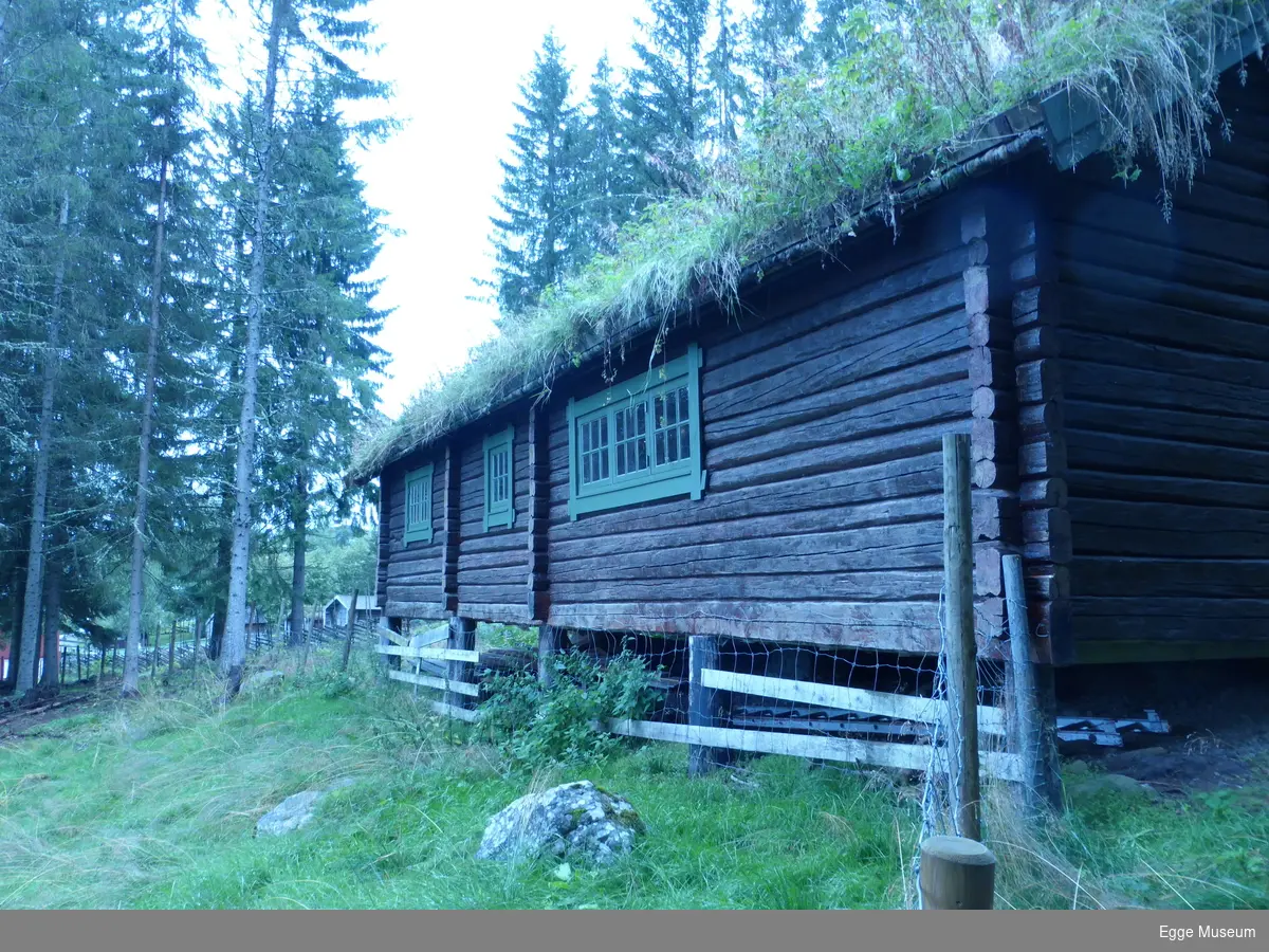 Laftet tømmerbygning av gran. 2 dører. Ei med låskasse, og ei med slå på innsida. 6 vinduer.