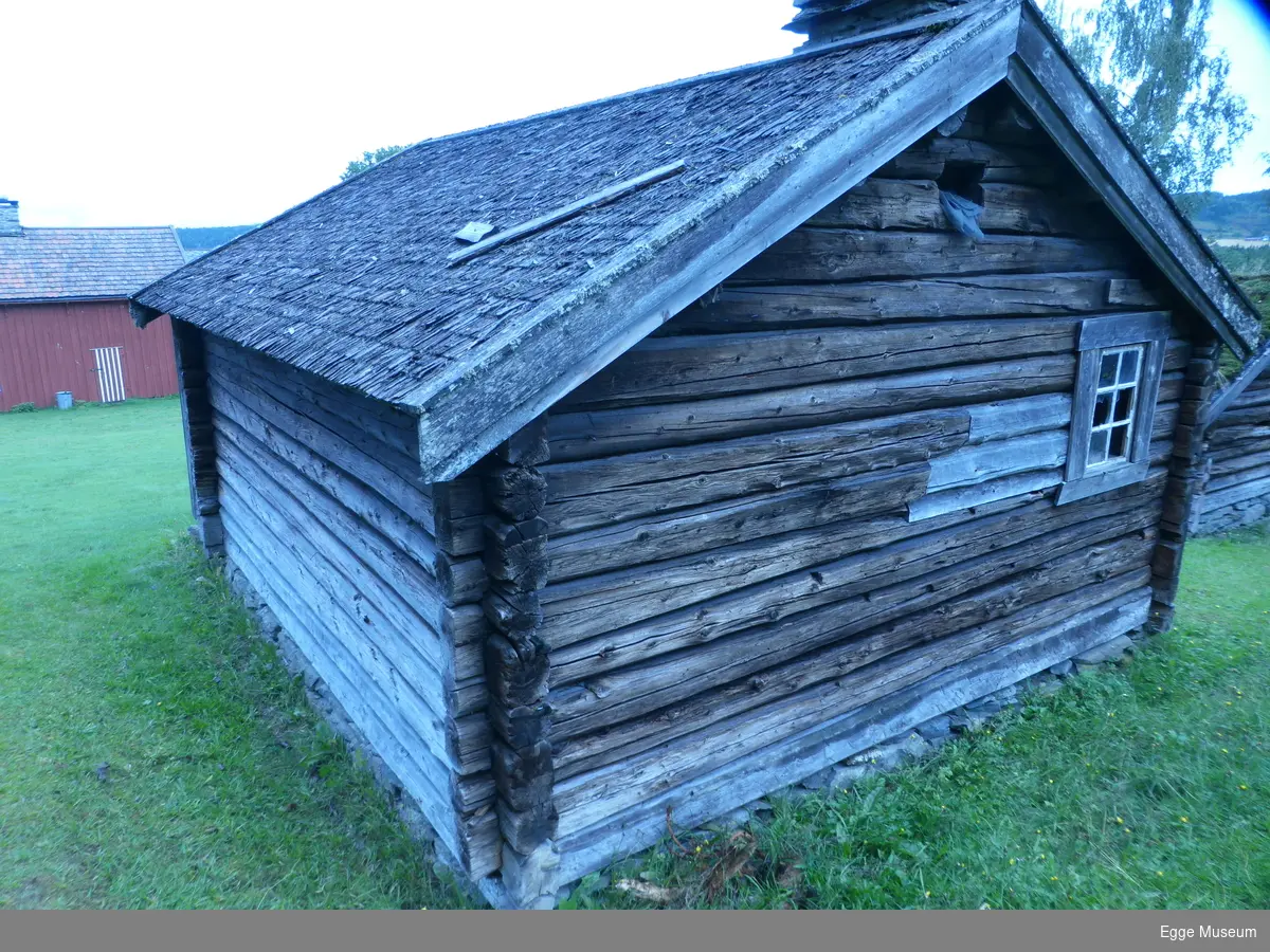 Laftet enetasjes tømmerbygning av gran. Ei enkel dør med jernslå og hengelås. Et vindu med seks ruter.