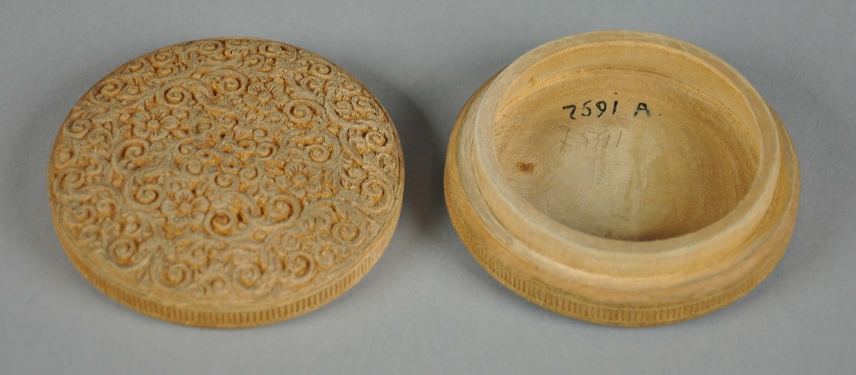 Rund eske av tre, med lokk. På lokket er det symmetriske treskjæringer av akantusmønster og blomster, med valknute på midten. Under esken er det konsentriske sirkler. På siden av esken og på siden av lokket er det border med tverrlinjer.