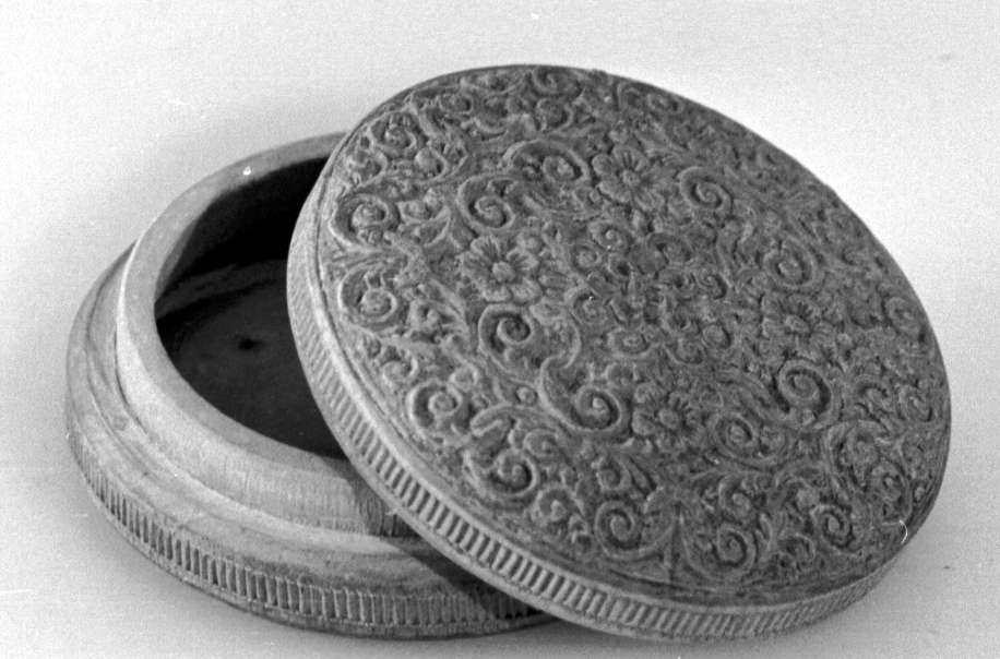 Rund eske av tre, med lokk. På lokket er det symmetriske treskjæringer av akantusmønster og blomster, med valknute på midten. Under esken er det konsentriske sirkler. På siden av esken og på siden av lokket er det border med tverrlinjer.