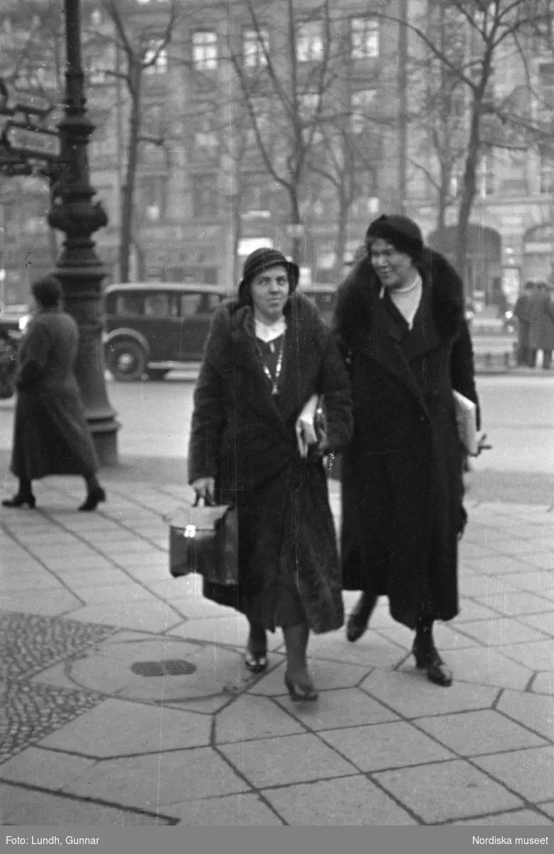 Motiv: Tyskland, Rankestrasse, Berlin, fröken Andersson, fru Rydelius;
Porträtt av två kvinnor som går på en stadsgata, en kvinna med svarta glasögon sitter i en port, stadsvy med fotgängare och en spårvagn.

Motiv: Tyskland, Berlin bl. a. Fredrichstrasse;
Skyltfönster med text "Gr. Mittagtisch! Kein Bedienungsgeld Kein Trinkzwang" och ett plakat uppsatt på fönstret, stadsvy med fotgängare och bilar, skyltfönster med text "Grog von Rum ....." "Fernsprechen", skyltfönster med text "Mittag u. Abend Gedeck 50" "Hier essen Sie besser und billiger" "Speise - Restaurant", skyltfönster med text "Gedecke bis 7 Uhr Abends 3 Gänge - 50 Grosse Auswahl."