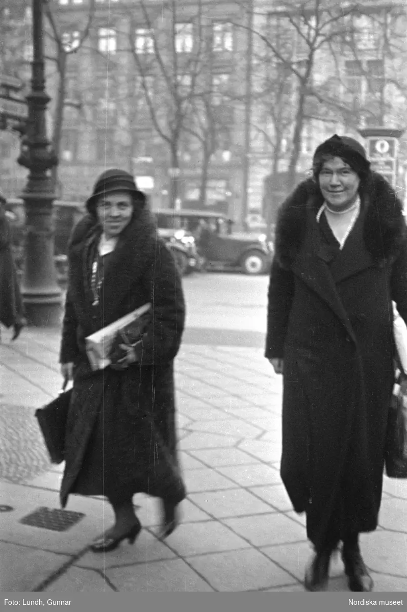 Motiv: Tyskland, Rankestrasse, Berlin, fröken Andersson, fru Rydelius;
Porträtt av två kvinnor som går på en stadsgata, en kvinna med svarta glasögon sitter i en port, stadsvy med fotgängare och en spårvagn.

Motiv: Tyskland, Berlin bl. a. Fredrichstrasse;
Skyltfönster med text "Gr. Mittagtisch! Kein Bedienungsgeld Kein Trinkzwang" och ett plakat uppsatt på fönstret, stadsvy med fotgängare och bilar, skyltfönster med text "Grog von Rum ....." "Fernsprechen", skyltfönster med text "Mittag u. Abend Gedeck 50" "Hier essen Sie besser und billiger" "Speise - Restaurant", skyltfönster med text "Gedecke bis 7 Uhr Abends 3 Gänge - 50 Grosse Auswahl."