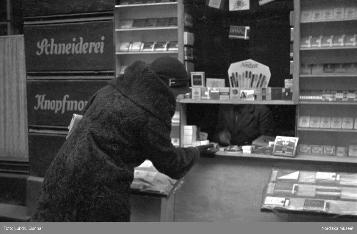 Motiv: Tyskland, Rankestrasse, Berlin, fröken Andersson, fru Rydelius;
Porträtt av två kvinnor som går på en stadsgata, en kvinna med svarta glasögon sitter i en port, stadsvy med fotgängare och en spårvagn.

Motiv: Tyskland, Berlin bl. a. Fredrichstrasse;
Skyltfönster med text "Gr. Mittagtisch! Kein Bedienungsgeld Kein Trinkzwang" och ett plakat uppsatt på fönstret, stadsvy med fotgängare och bilar, skyltfönster med text "Grog von Rum ....." "Fernsprechen", skyltfönster med text "Mittag u. Abend Gedeck 50" "Hier essen Sie besser und billiger" "Speise - Restaurant", skyltfönster med text "Gedecke bis 7 Uhr Abends 3 Gänge - 50 Grosse Auswahl."