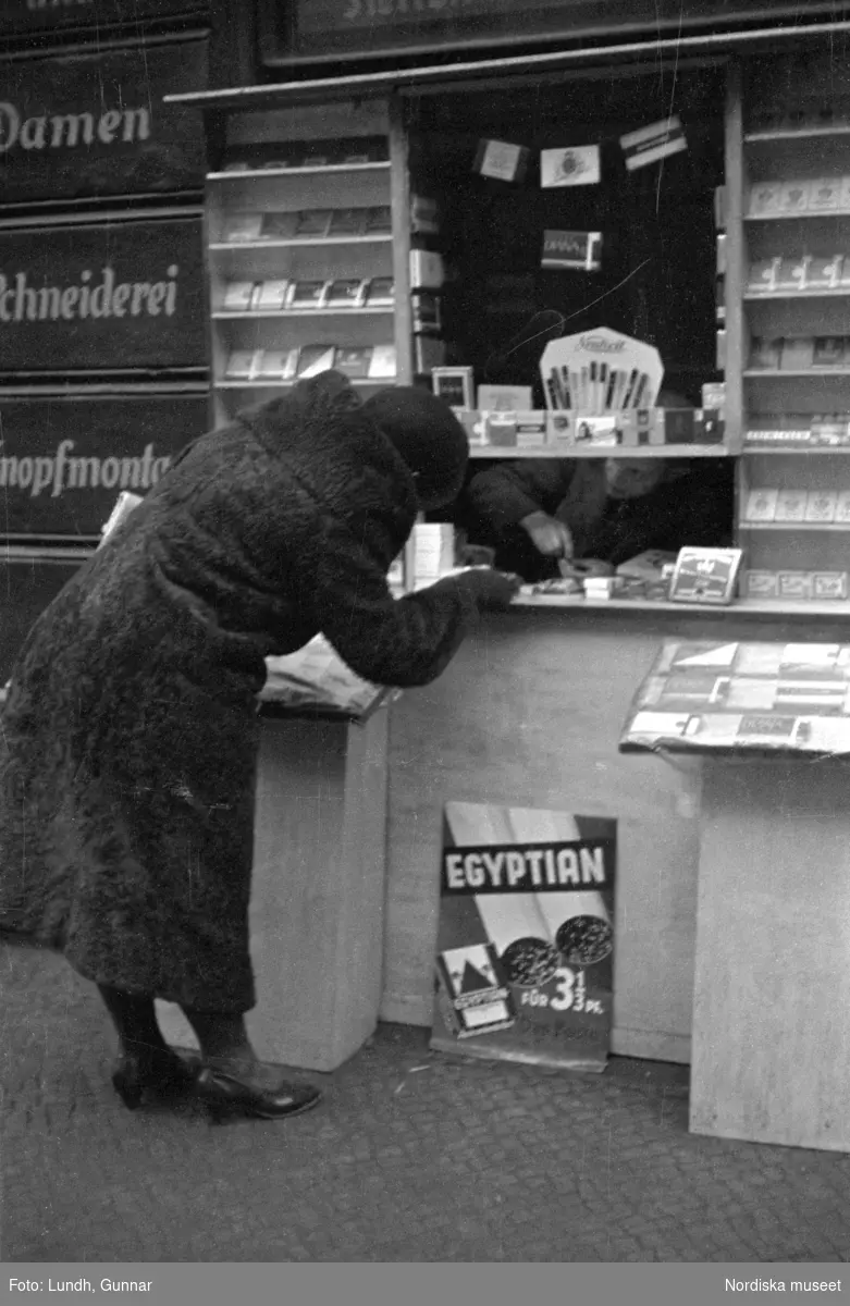 Motiv: Tyskland, Rankestrasse, Berlin, fröken Andersson, fru Rydelius;
Porträtt av två kvinnor som går på en stadsgata, en kvinna med svarta glasögon sitter i en port, stadsvy med fotgängare och en spårvagn.

Motiv: Tyskland, Berlin bl. a. Fredrichstrasse;
Skyltfönster med text "Gr. Mittagtisch! Kein Bedienungsgeld Kein Trinkzwang" och ett plakat uppsatt på fönstret, stadsvy med fotgängare och bilar, skyltfönster med text "Grog von Rum ....." "Fernsprechen", skyltfönster med text "Mittag u. Abend Gedeck 50" "Hier essen Sie besser und billiger" "Speise - Restaurant", skyltfönster med text "Gedecke bis 7 Uhr Abends 3 Gänge - 50 Grosse Auswahl."