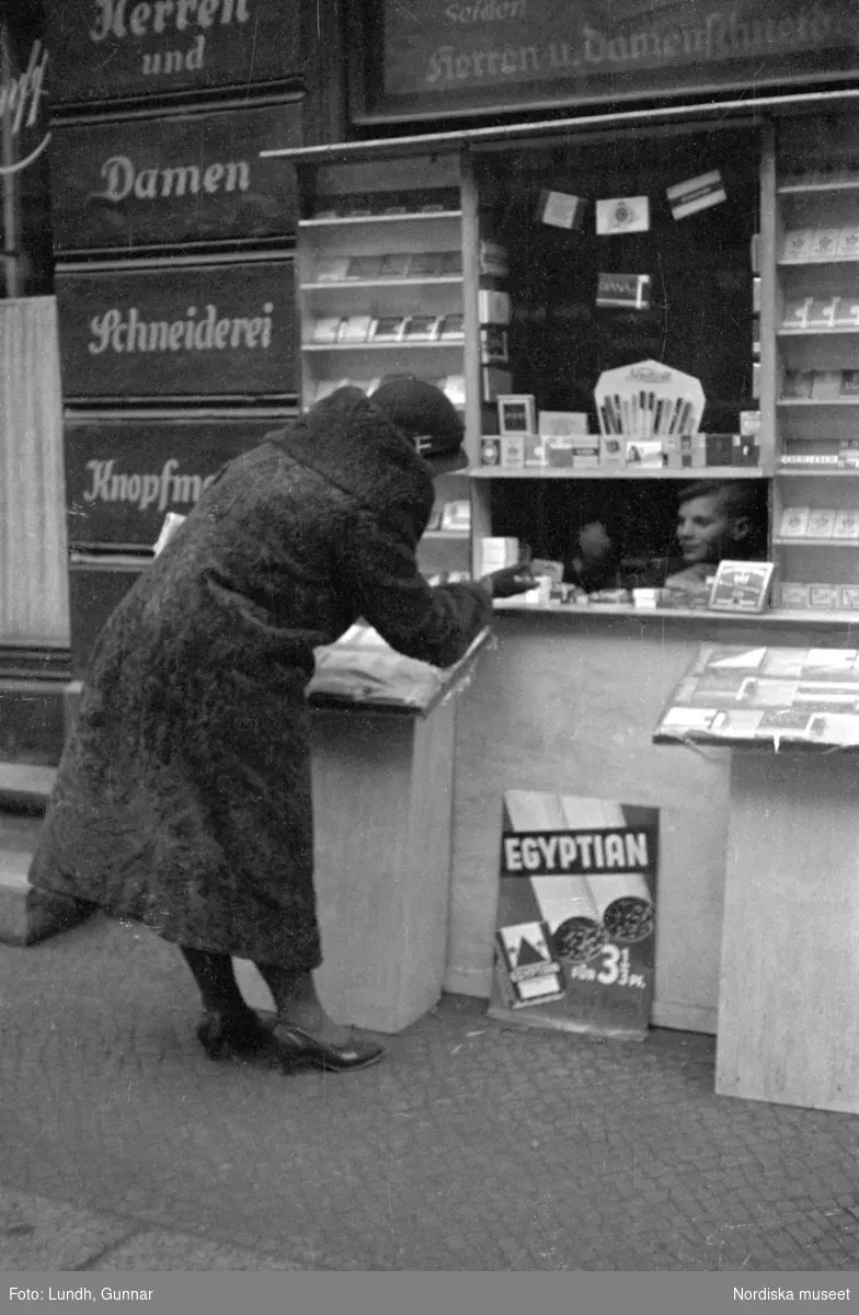 Motiv: Tyskland, Rankestrasse, Berlin, fröken Andersson, fru Rydelius;
Porträtt av två kvinnor som går på en stadsgata, en kvinna med svarta glasögon sitter i en port, stadsvy med fotgängare och en spårvagn.

Motiv: Tyskland, Berlin bl. a. Fredrichstrasse;
Skyltfönster med text "Gr. Mittagtisch! Kein Bedienungsgeld Kein Trinkzwang" och ett plakat uppsatt på fönstret, stadsvy med fotgängare och bilar, skyltfönster med text "Grog von Rum ....." "Fernsprechen", skyltfönster med text "Mittag u. Abend Gedeck 50" "Hier essen Sie besser und billiger" "Speise - Restaurant", skyltfönster med text "Gedecke bis 7 Uhr Abends 3 Gänge - 50 Grosse Auswahl."